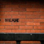 The word "breathe" is written on the brick wall