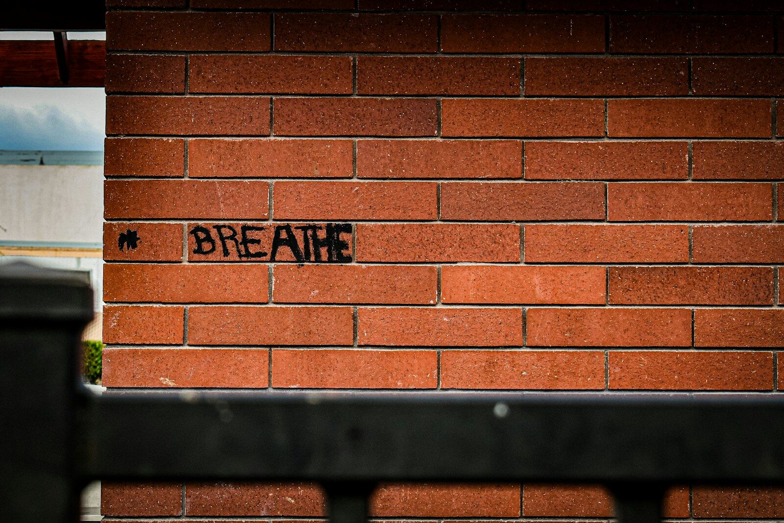 The word "breathe" is written on the brick wall